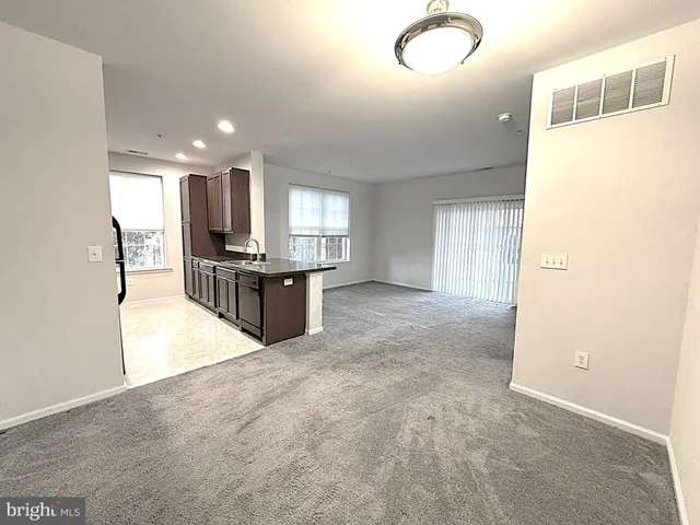 a view of a kitchen with refrigerator and a sink
