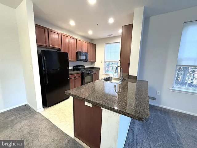 a kitchen with stainless steel appliances granite countertop a refrigerator a sink a stove a microwave and island