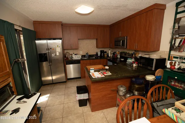 a kitchen with stainless steel appliances granite countertop a refrigerator a stove a sink and a stove