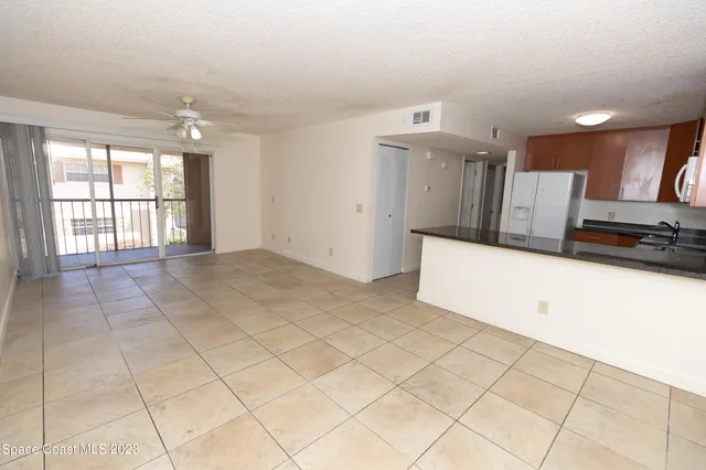a kitchen with refrigerator and chairs