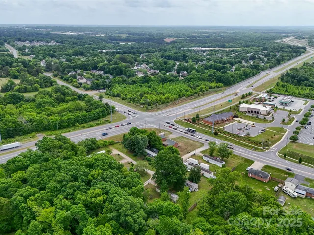 an aerial view of residential houses with outdoor space and trees