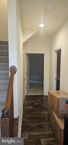 a view of a hallway with entryway and wooden floor