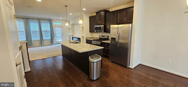 a kitchen with stainless steel appliances granite countertop a refrigerator a stove and a sink