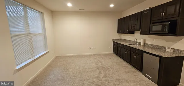 a kitchen with granite countertop a sink and a stove top oven