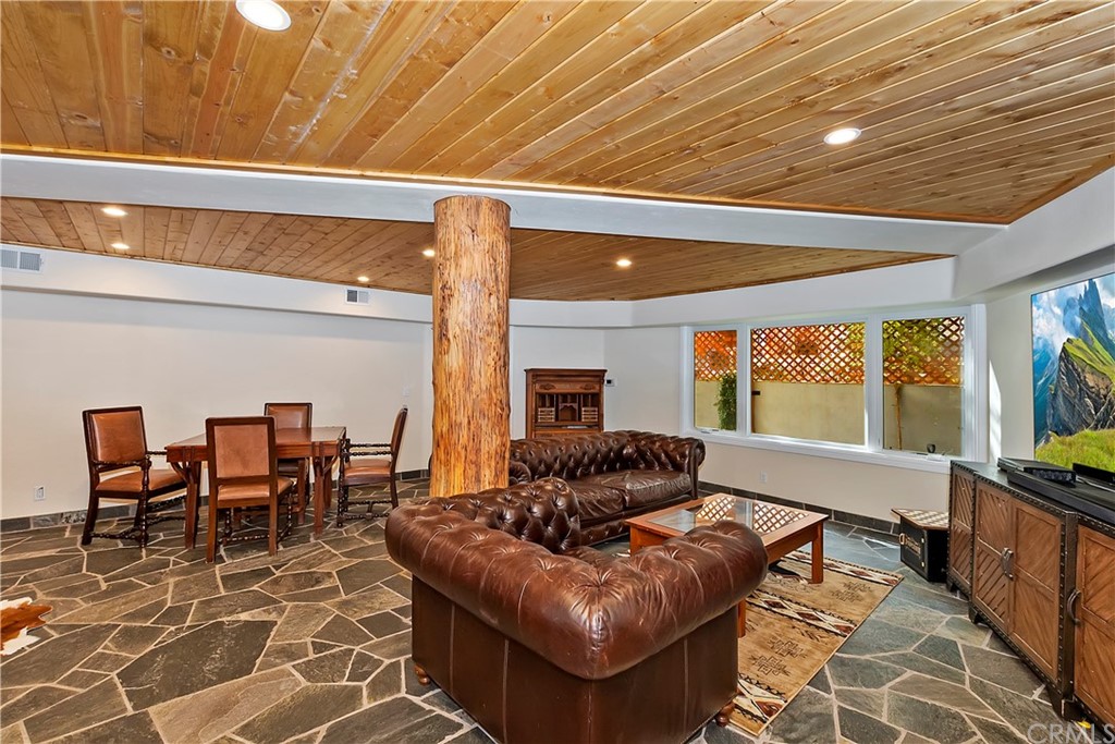 27880 Peninsula Drive North Lake Arrowhead, CA 92352 - Photo 47 of 69 a living room with furniture a flat screen tv and floor to ceiling window