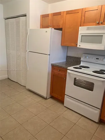 a white refrigerator freezer and a stove sitting inside of a kitchen