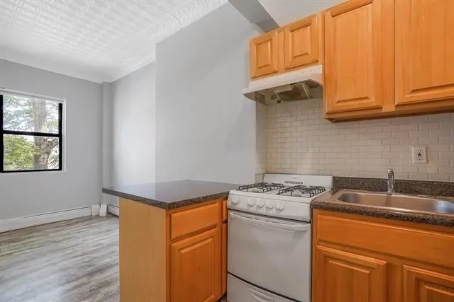 a kitchen with granite countertop cabinets stainless steel appliances and a sink
