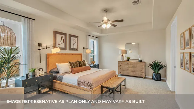 a bedroom with a large bed and a chandelier fan