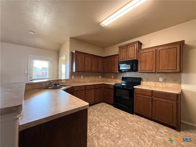 a kitchen with stainless steel appliances granite countertop a sink dishwasher stove and oven