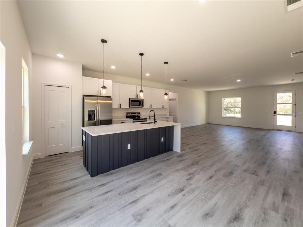 14481 Southwest 29th Terrace Ocala, FL 34473 - Photo 5 of 31 a kitchen with stainless steel appliances kitchen island wooden cabinets and window