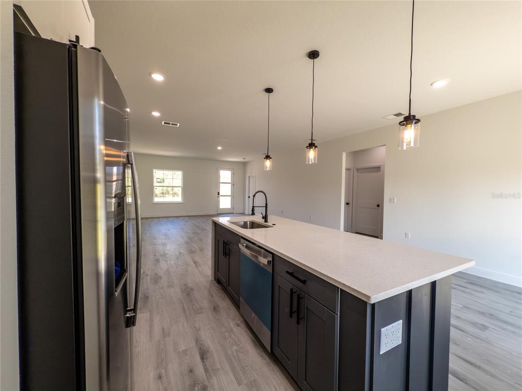 14481 Southwest 29th Terrace Ocala, FL 34473 - Photo 6 of 31 a kitchen with kitchen island a sink appliances and wooden floor