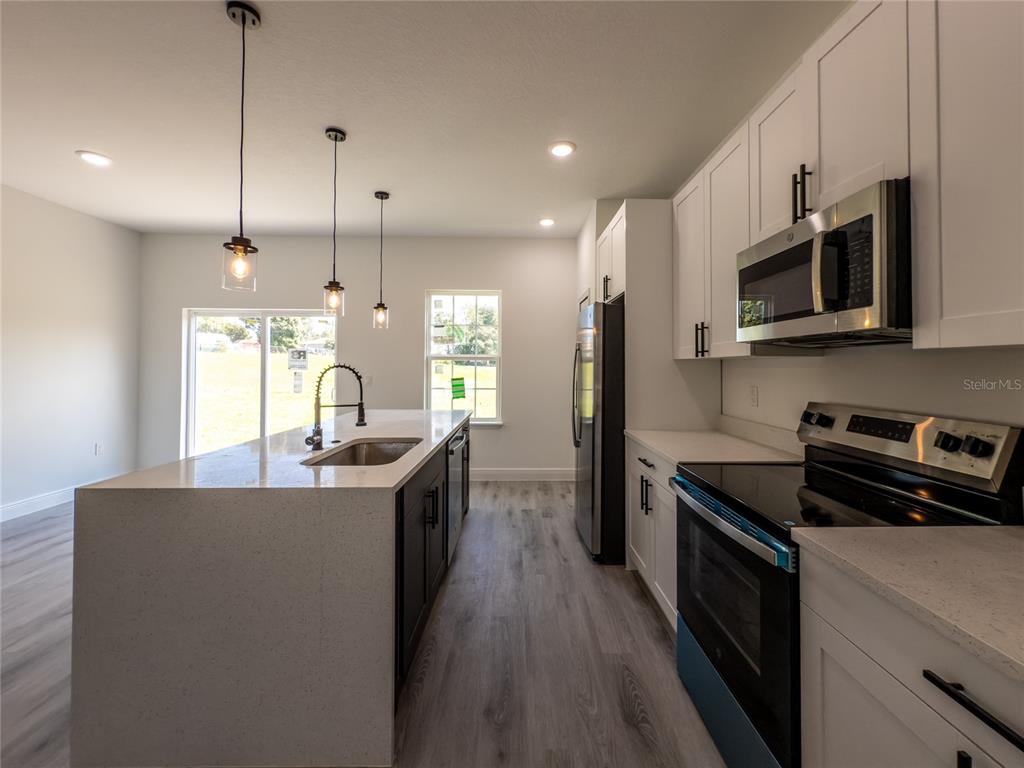 14481 Southwest 29th Terrace Ocala, FL 34473 - Photo 9 of 31 a kitchen with stainless steel appliances granite countertop a stove a sink and a refrigerator