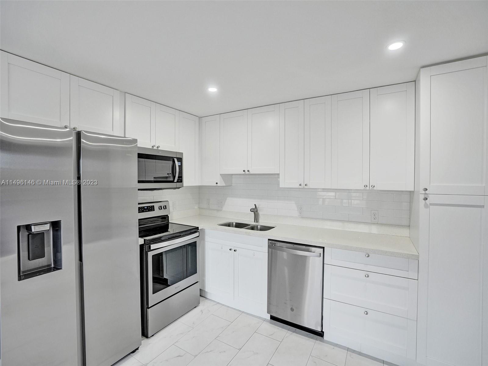 a kitchen with white cabinets and white appliances