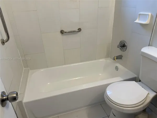 a white toilet sitting next to a bath tub