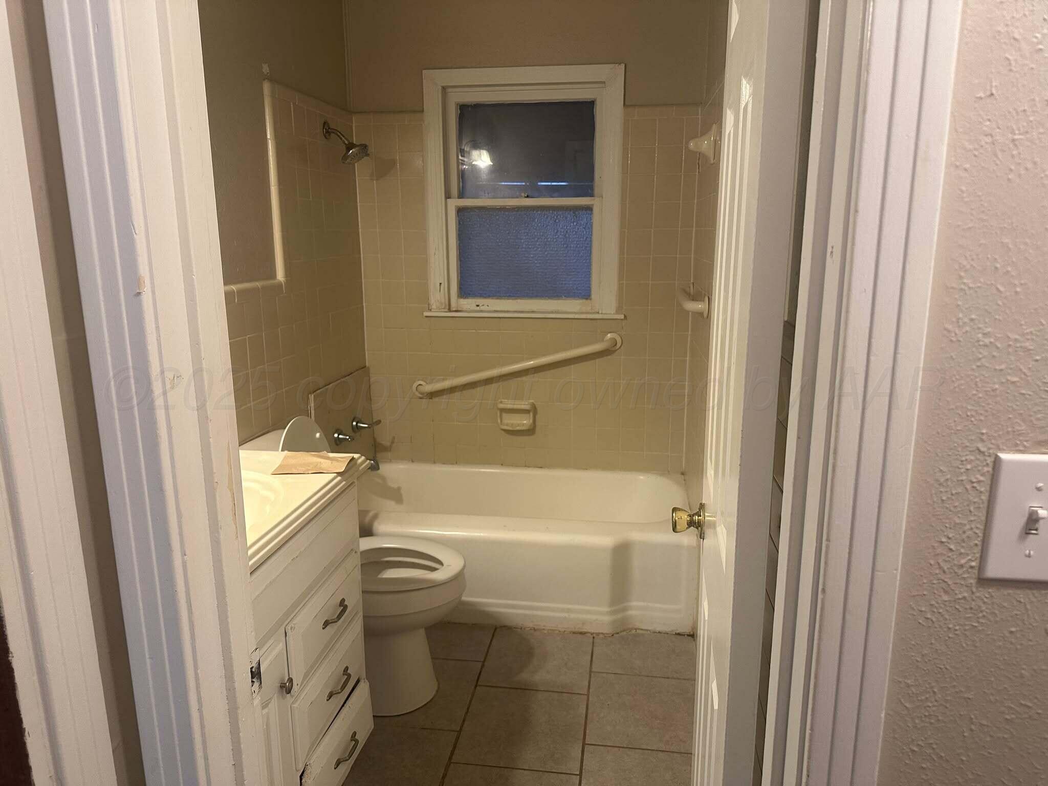 1933 South Seminole Street Amarillo, TX 79103 - Photo 4 of 7 a bathroom with a toilet and a bathtub