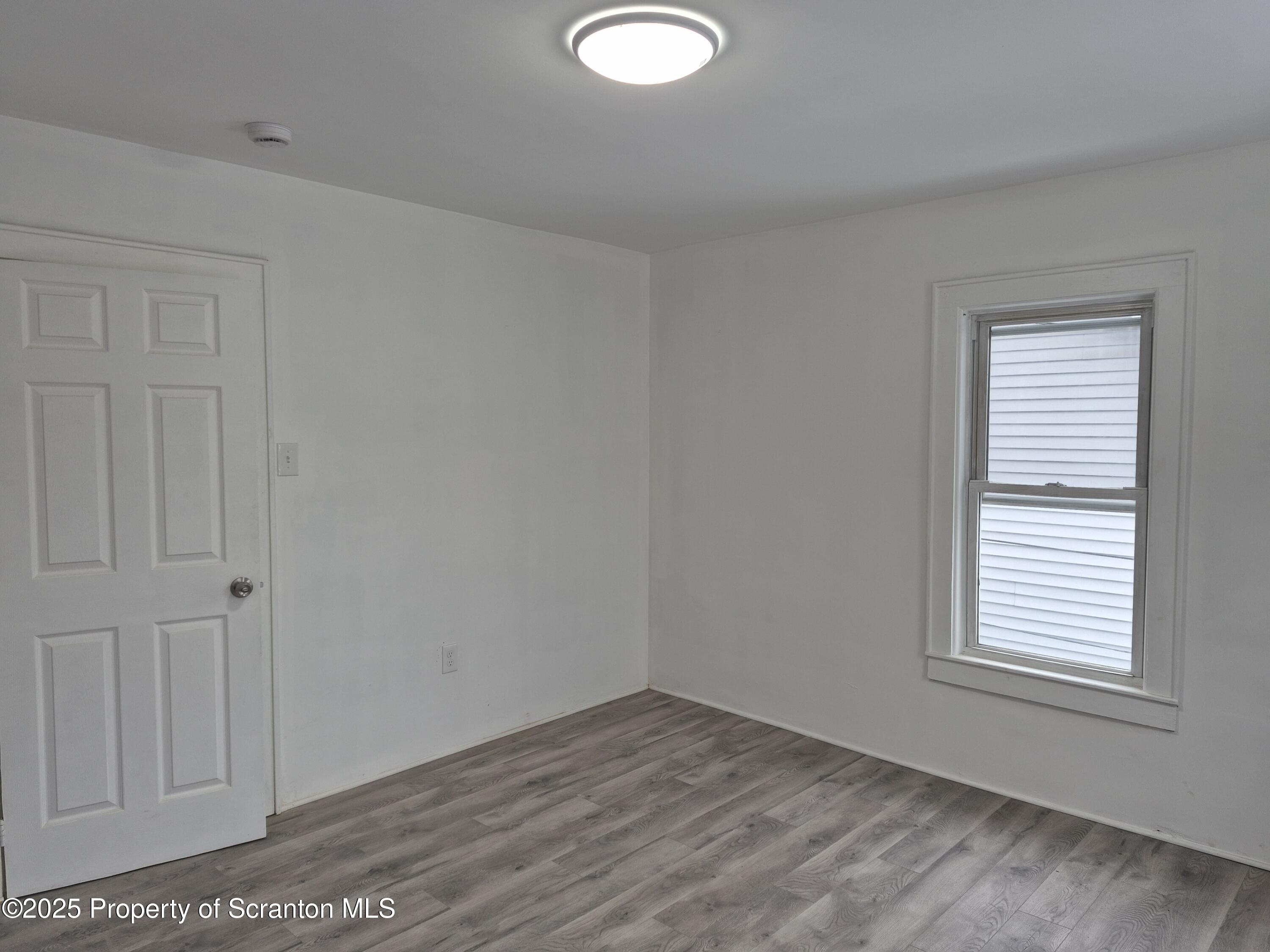 1758 Wayne Avenue Scranton, PA 18508 - Photo 11 of 20 an empty room with wooden floor and windows