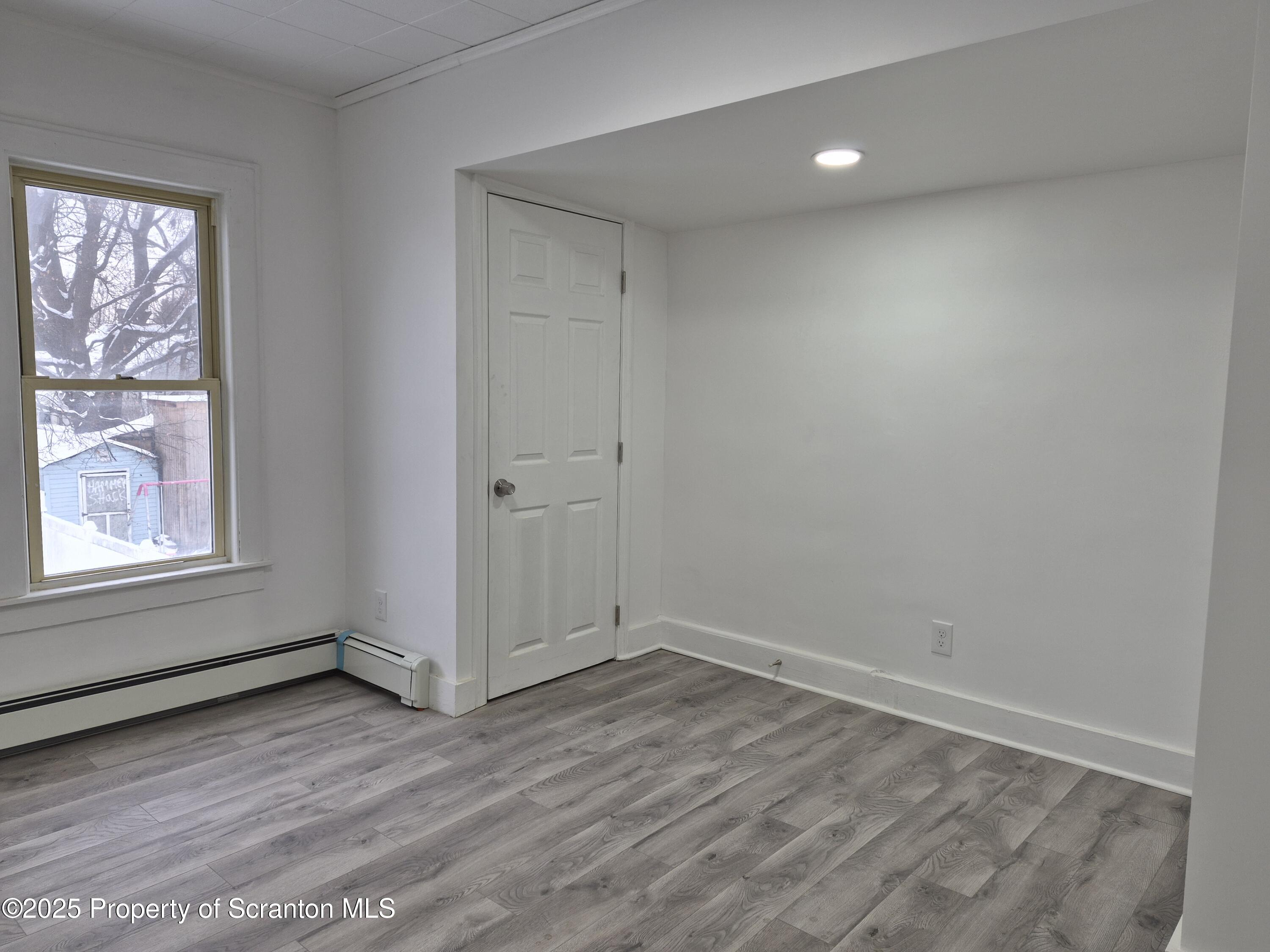 1758 Wayne Avenue Scranton, PA 18508 - Photo 13 of 20 a view of an empty room with wooden floor and a window