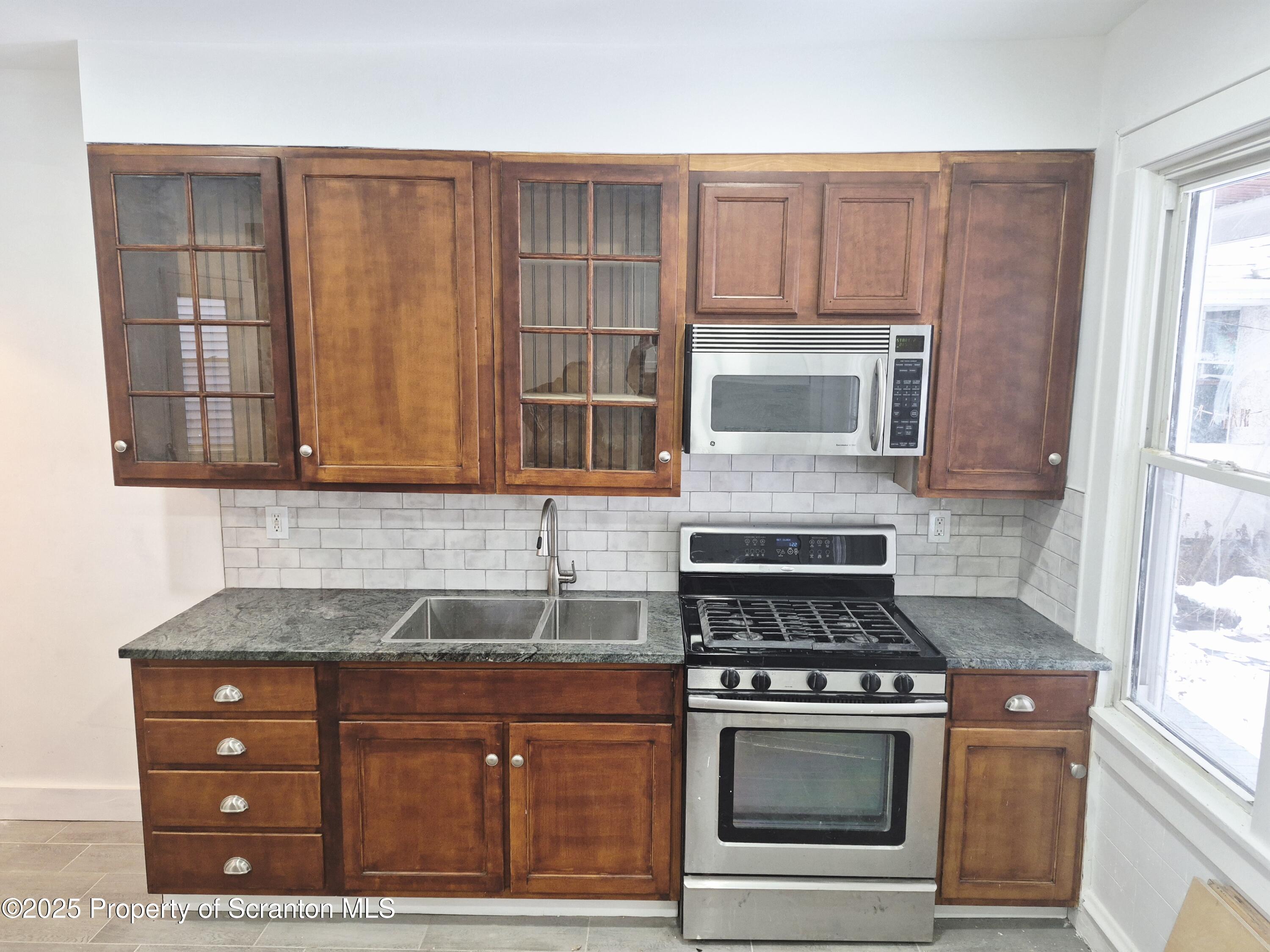 1758 Wayne Avenue Scranton, PA 18508 - Photo 8 of 20 a kitchen with granite countertop a stove and a sink