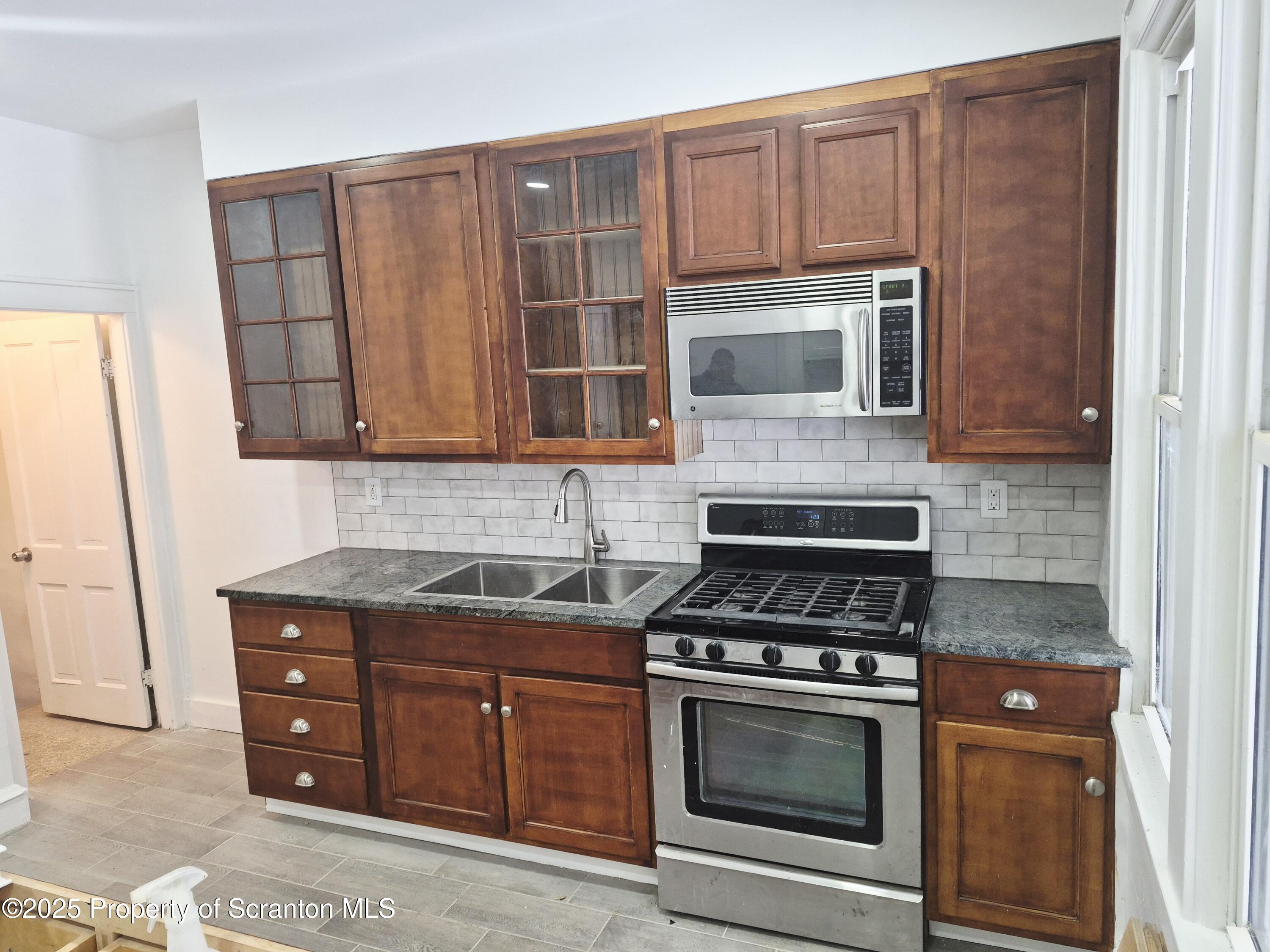 1758 Wayne Avenue Scranton, PA 18508 - Photo 9 of 20 a kitchen with granite countertop a stove and a microwave