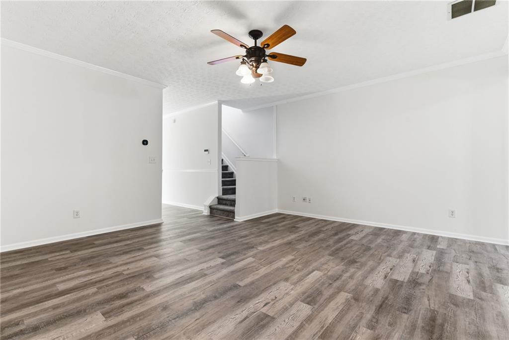 2913 Greyhawk Lane Cumming, GA 30040 - Photo 9 of 44 an empty room with wooden floor and ceiling fan