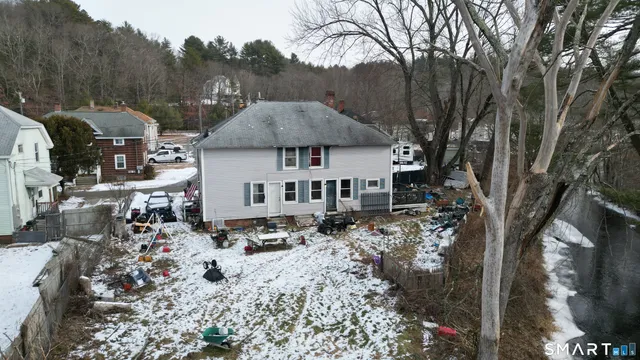 a view of a town with trees covered with snow in the background