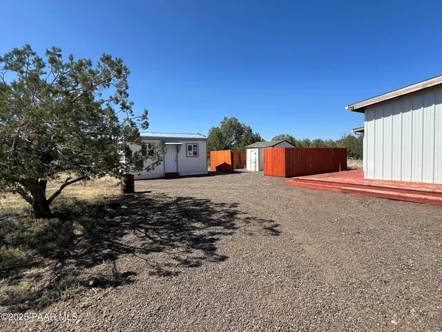 a backyard of a house with table and chairs