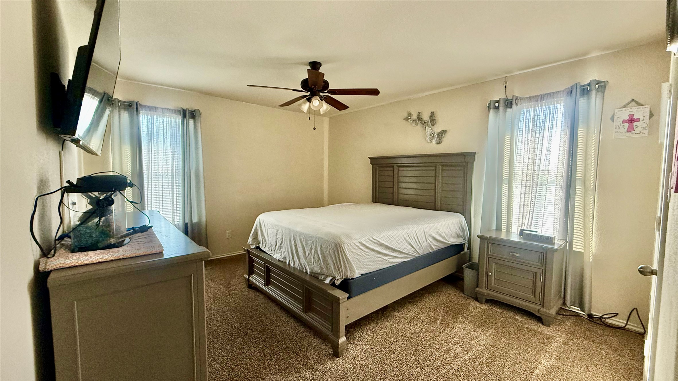 18309 Wind Tree Lane Elgin, TX 78621 - Photo 19 of 29 Natural light streams through multiple windows onto the wall-to-wall carpeting of this bedroom.
