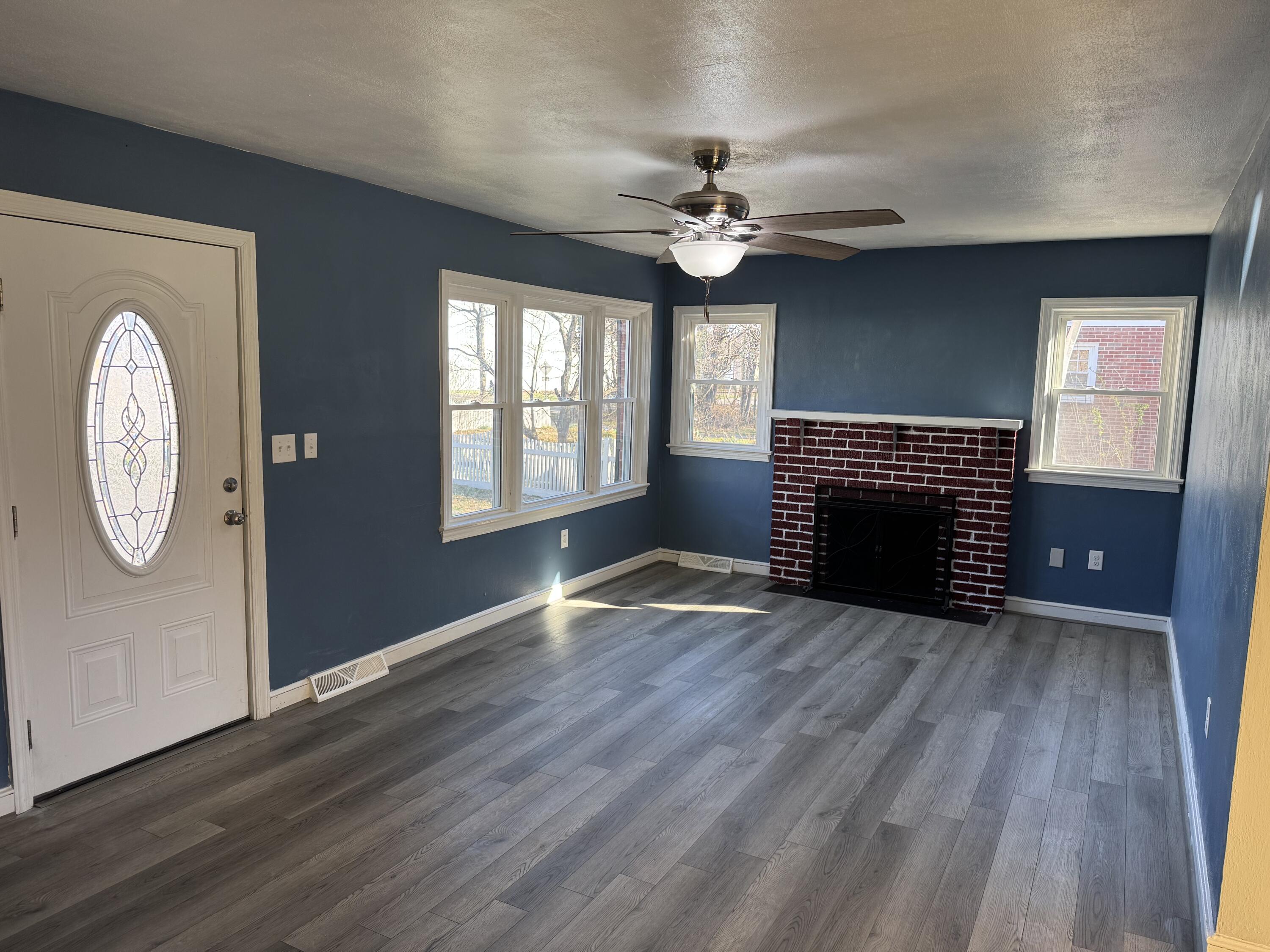 509 Kessler Mill Road, Unit 509 Salem, VA 24153 - Photo 3 of 30 a view of an empty room with wooden floor fireplace and a window