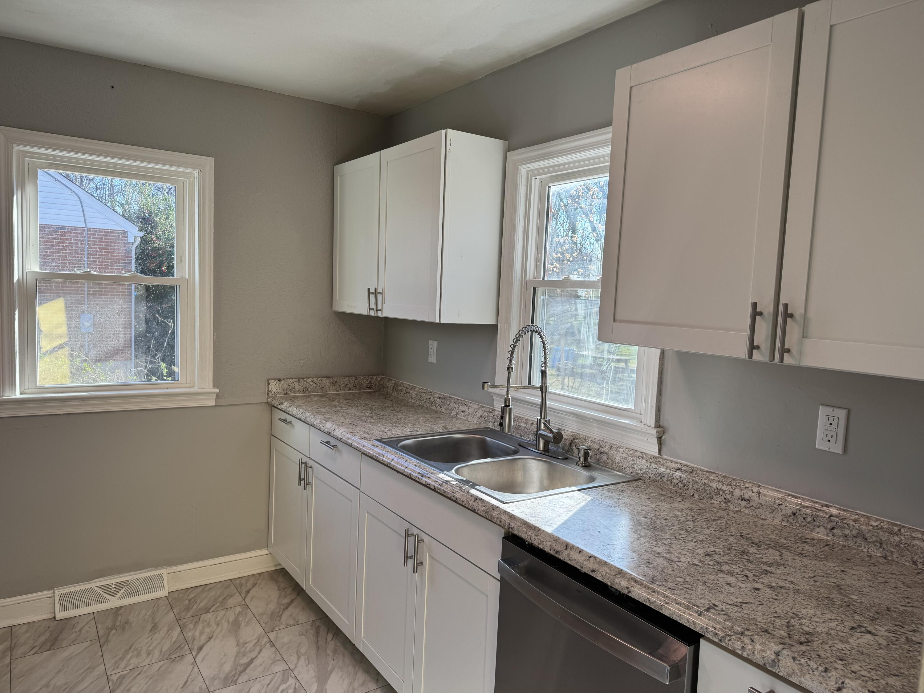 509 Kessler Mill Road, Unit 509 Salem, VA 24153 - Photo 7 of 30 a kitchen with granite countertop a sink white cabinets and a window