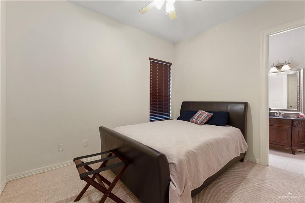 210 North 18th Street Hidalgo, TX 78557 - Photo 16 of 24 Bedroom with light colored carpet, ceiling fan, and ensuite bath