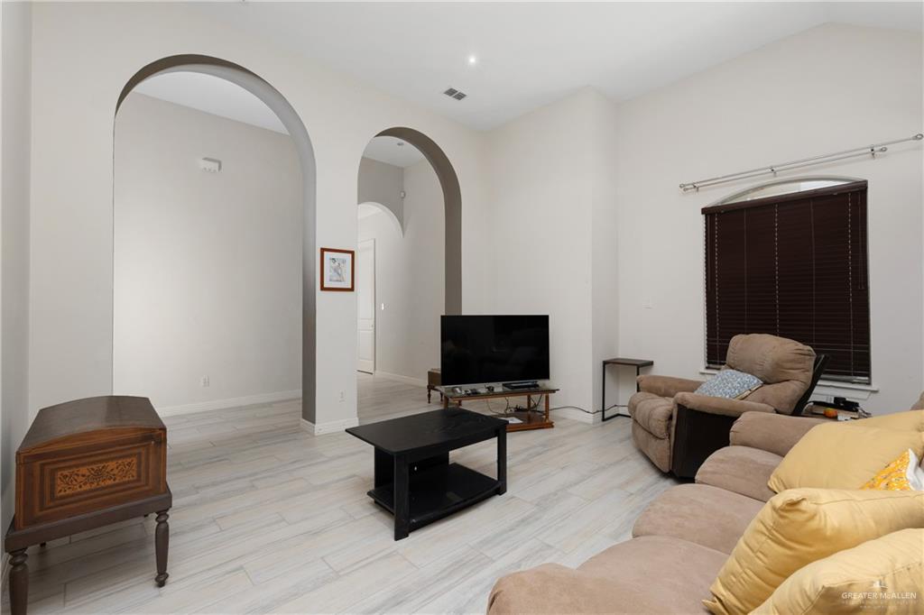 210 North 18th Street Hidalgo, TX 78557 - Photo 2 of 24 Living room featuring arched walkways and light wood-style floors
