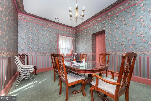 a view of a dining room with furniture and chandelier