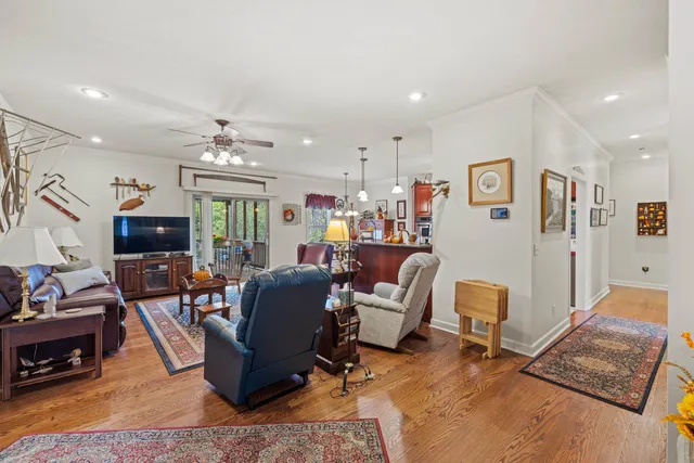 a living room with furniture a ceiling fan and a rug