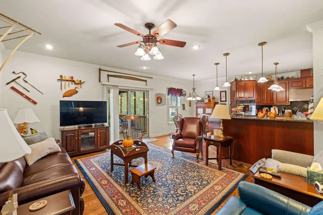 a dining room with furniture a chandelier and wooden floor