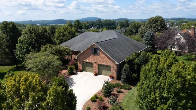 an aerial view of house with yard and trees in the background