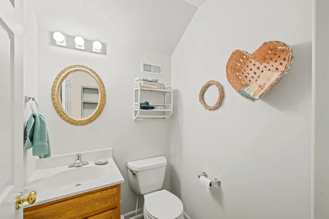 a bathroom with a toilet a sink and mirror