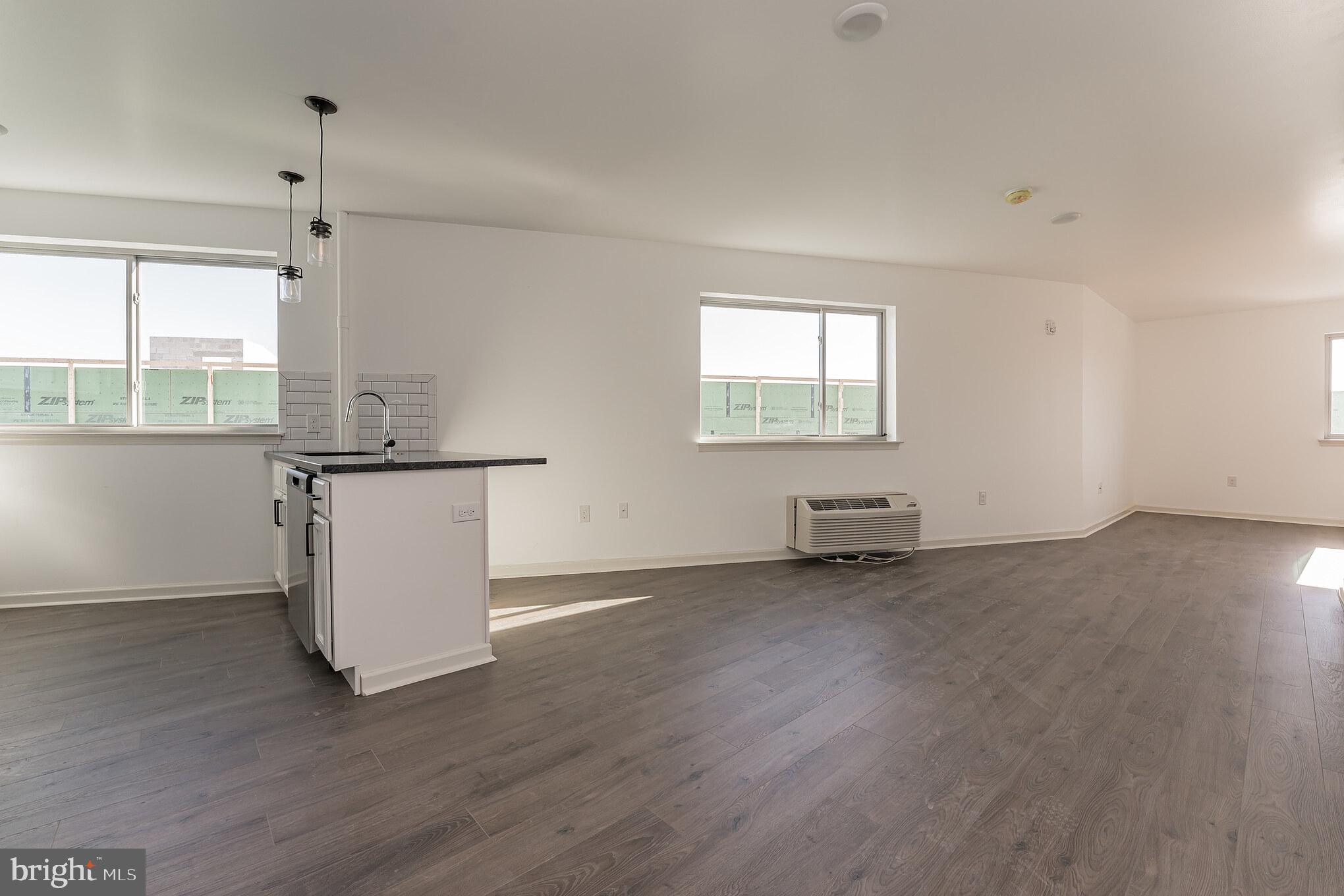 6649 Ridge Avenue, Unit A416 Philadelphia, PA 19128 - Photo 4 of 7 an empty room with wooden floor and windows