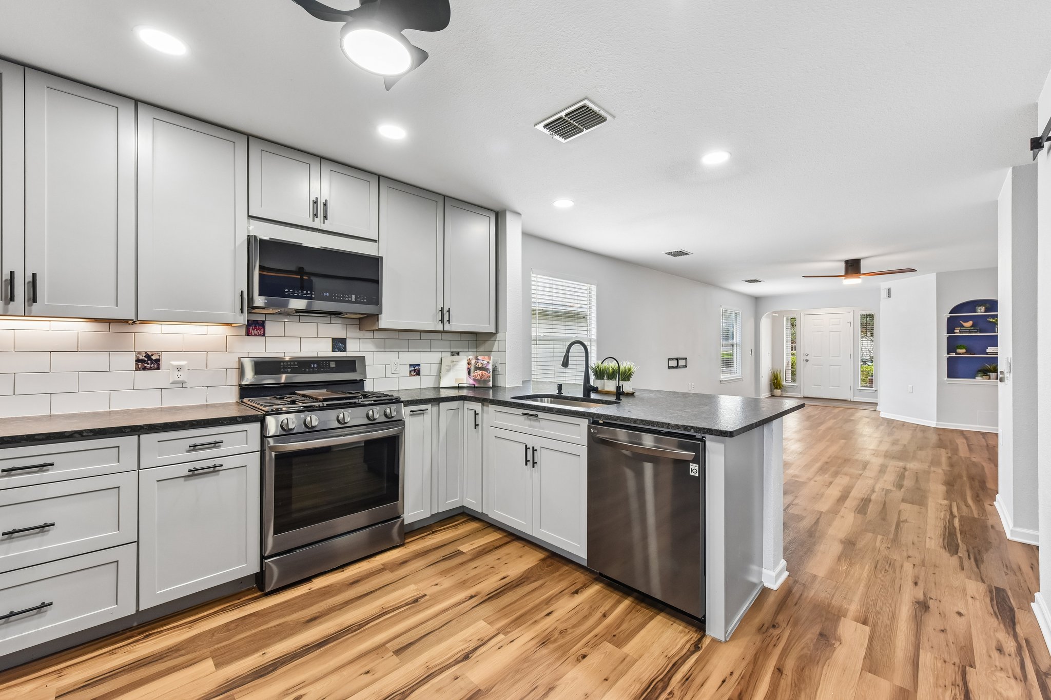 5405 Rusk Court Austin, TX 78723 - Photo 15 of 40 Modern kitchen with sleek stainless steel appliances opens to a naturally illuminated living space.