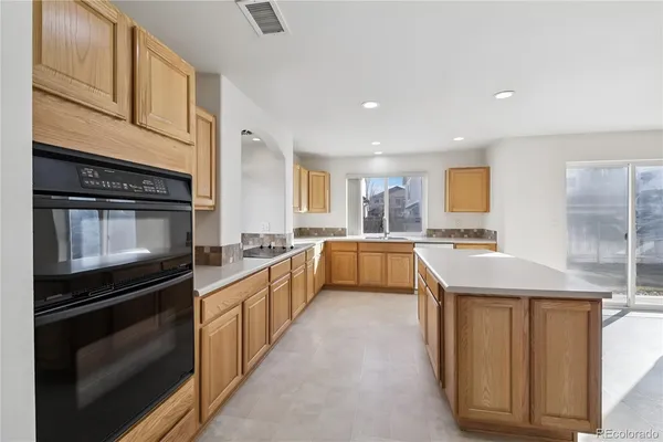 a kitchen with stainless steel appliances kitchen island granite countertop a stove and a sink