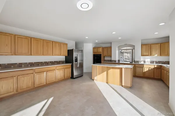 a large kitchen with stainless steel appliances granite countertop a large counter top and a stove top oven
