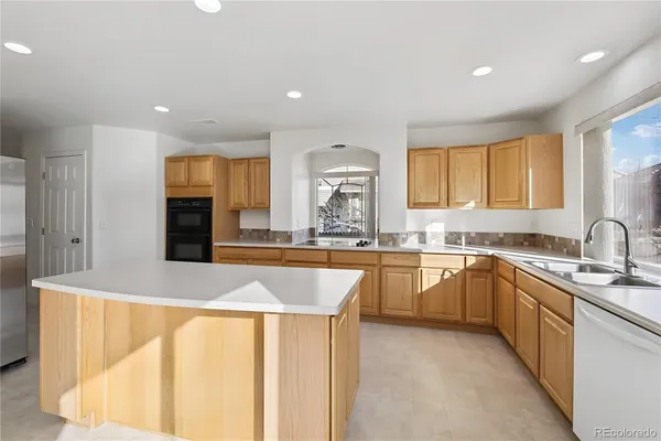 a large kitchen with stainless steel appliances granite countertop a sink and a stove