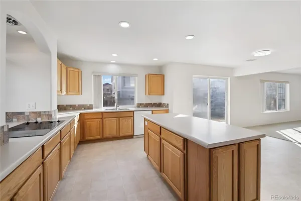 a kitchen with granite countertop a sink stove and cabinets