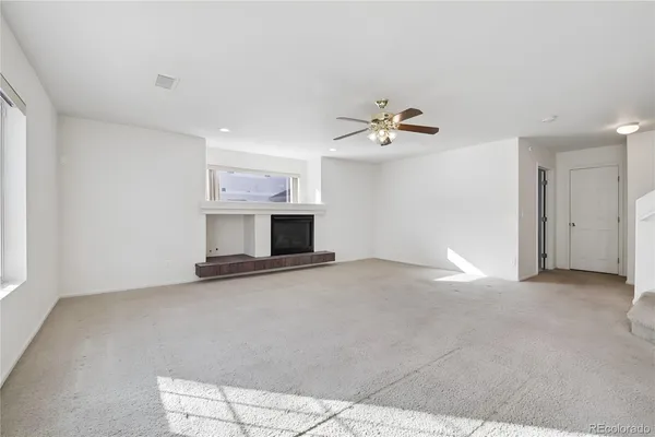 a view of empty room with fireplace and fan