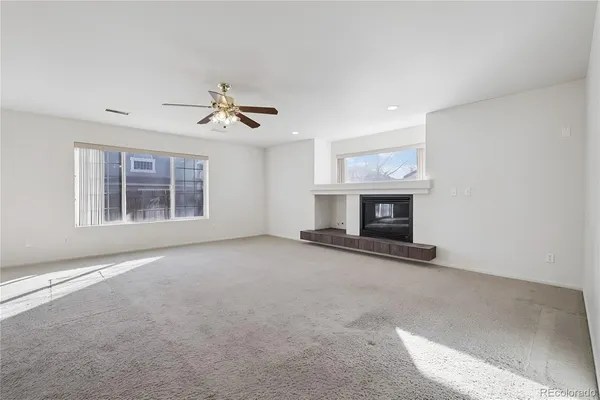 an empty room with windows and fireplace