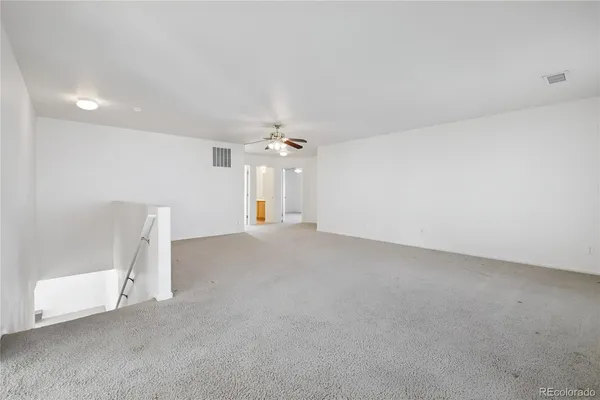 an empty room with a empty space and a ceiling fan