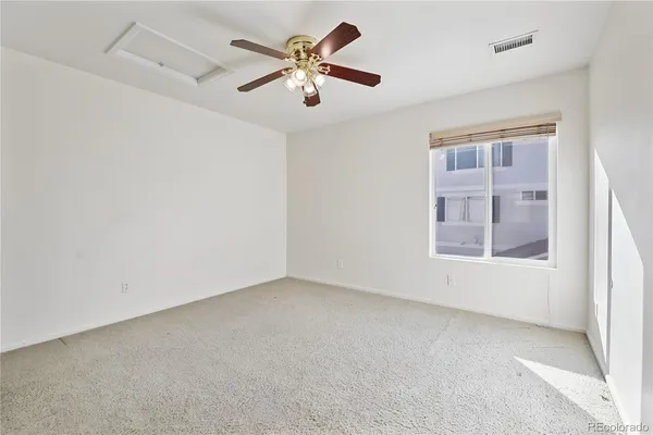 an empty room with a window and a fan