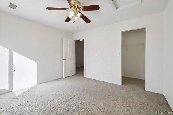 an empty room with chandelier fan