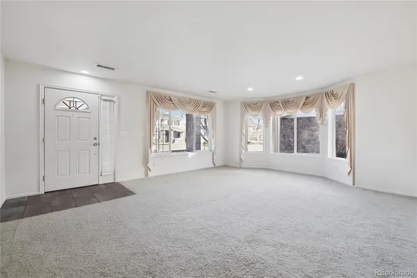 an empty room with windows and closet