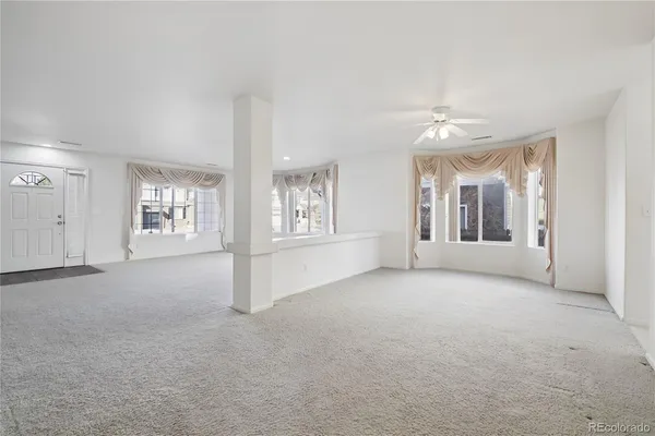 en empty room with windows and chandelier