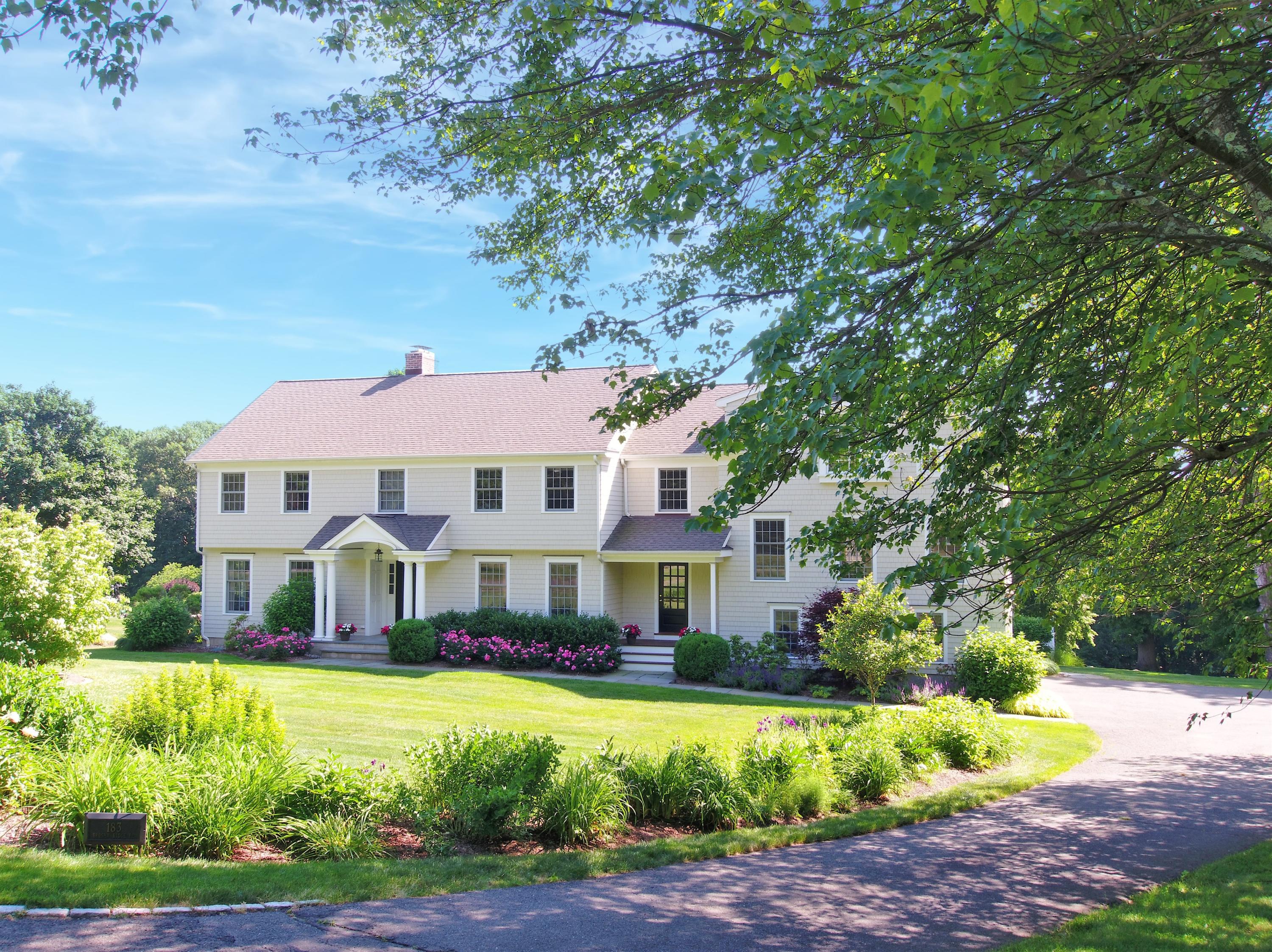 183 Brushy Ridge Road New Canaan, CT 06840 - Photo 2 of 41 a front view of a house with a yard table and chairs